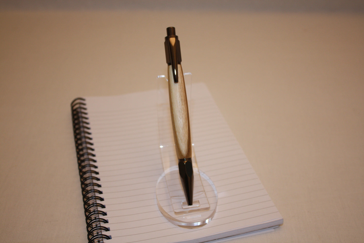 Stylo poussoir en acacia avec aubier. Ses extrémités ciselées offrent un grand confort d'écriture. Ce stylo a une écriture fine et utilise des recharges type Parker.