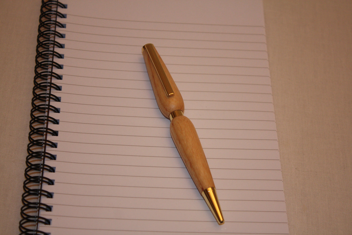 Stylo artisanal en frêne. Mécanisme quart-tournant, écriture noire.
