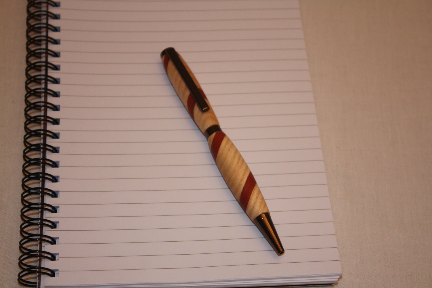 Stylo artisanal réalisé à partir de deux essences de bois : le frêne et le padouk. Ce stylo a une écriture noire.