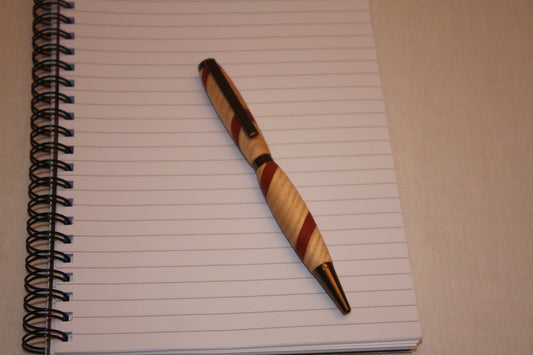 Stylo artisanal réalisé à partir de deux essences de bois : le frêne et le padouk. Ce stylo a une écriture noire.