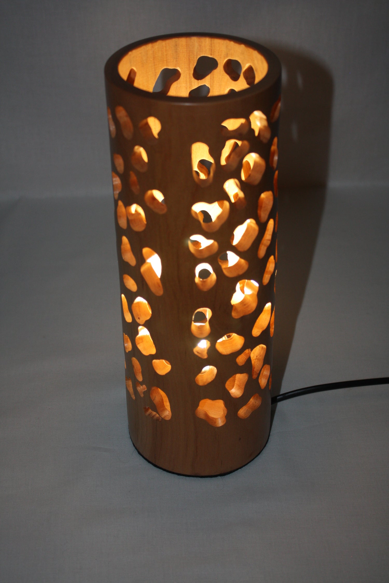 Lampe sculpté de manière artisanale dans un morceau de cerisier. Cette lampe fait 32 cmde haut et est une très belle lampe d'ambiance.