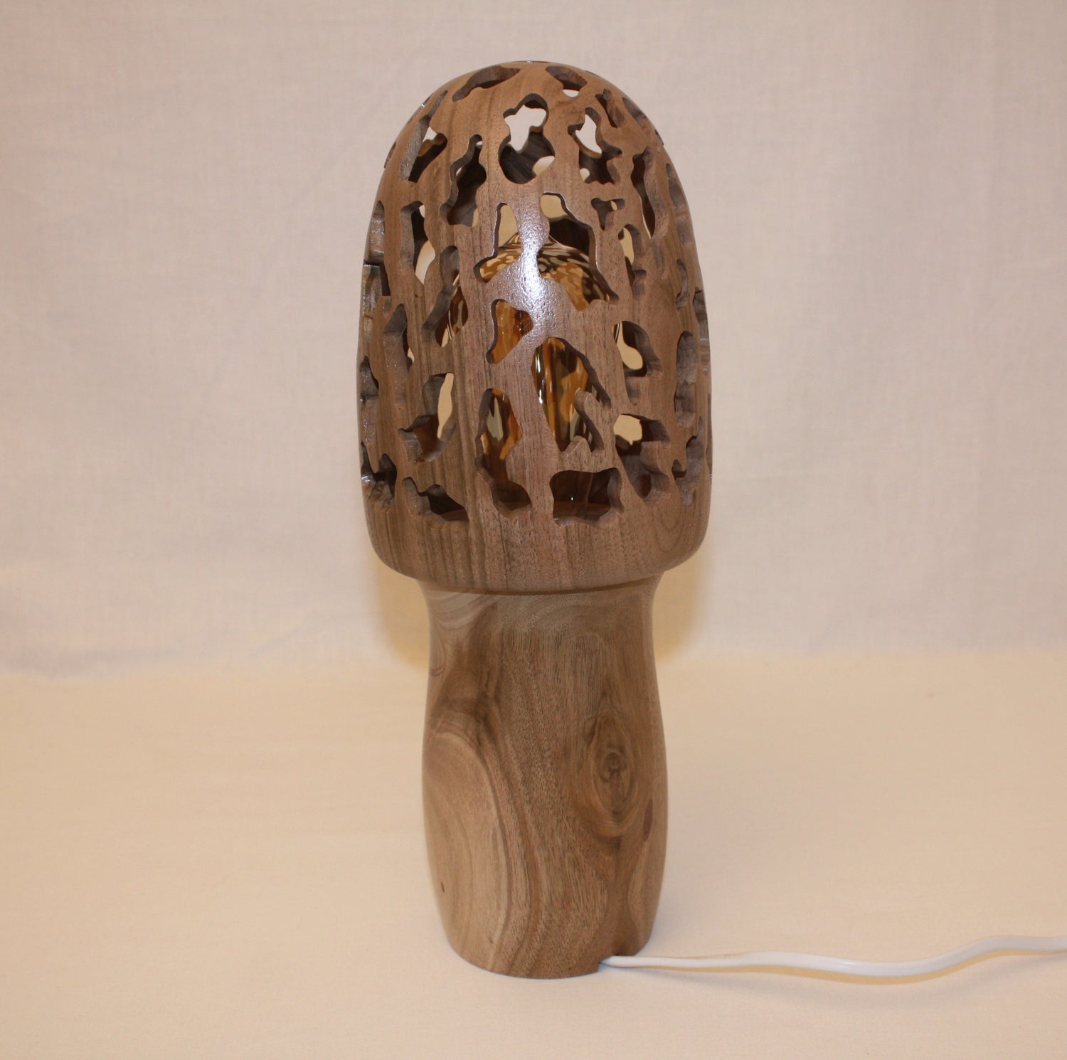 Lampe originale en bois qui a une forme de morille, la lampe mesure 35 cm de hauteur et est conçu entièrement de façon artisanale en bois de noyer.