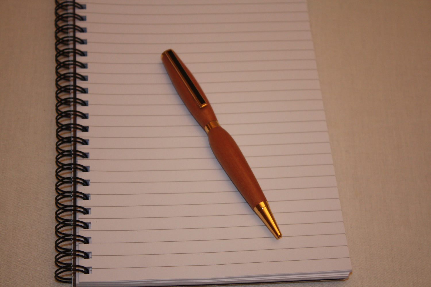 Stylo en alisier tourné manuellement. L'écriture de ce stylo est noire.