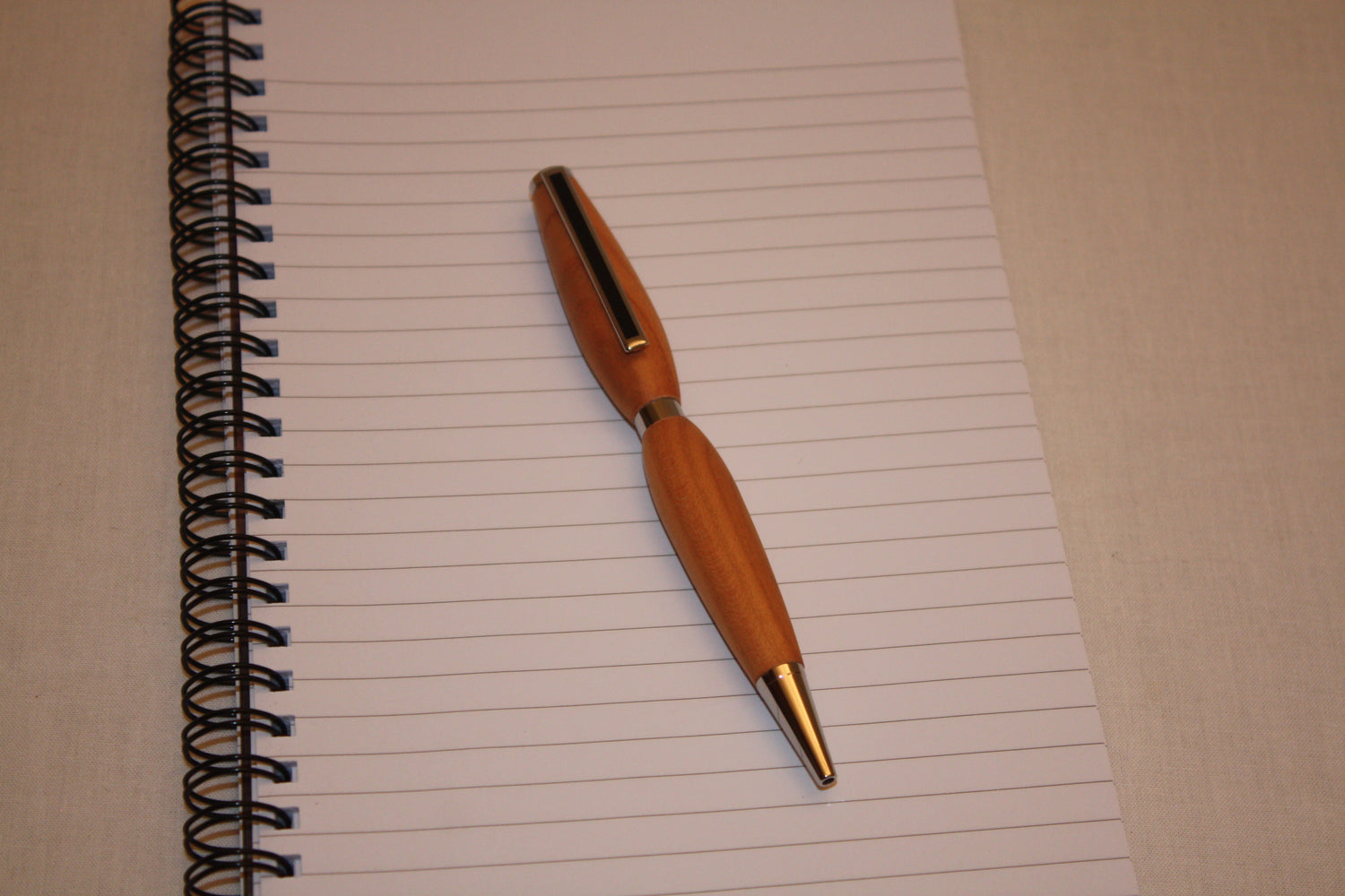 Stylo en merisier tourné artisanalement. Ecriture noire.