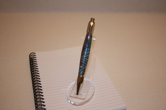 Stylo poussoir en pive de sapin et résine bleue et blanche. Ses extrémités ciselées offrent un grand confort d'écriture. Ce stylo a une écriture fine et utilise des recharges type Parker.