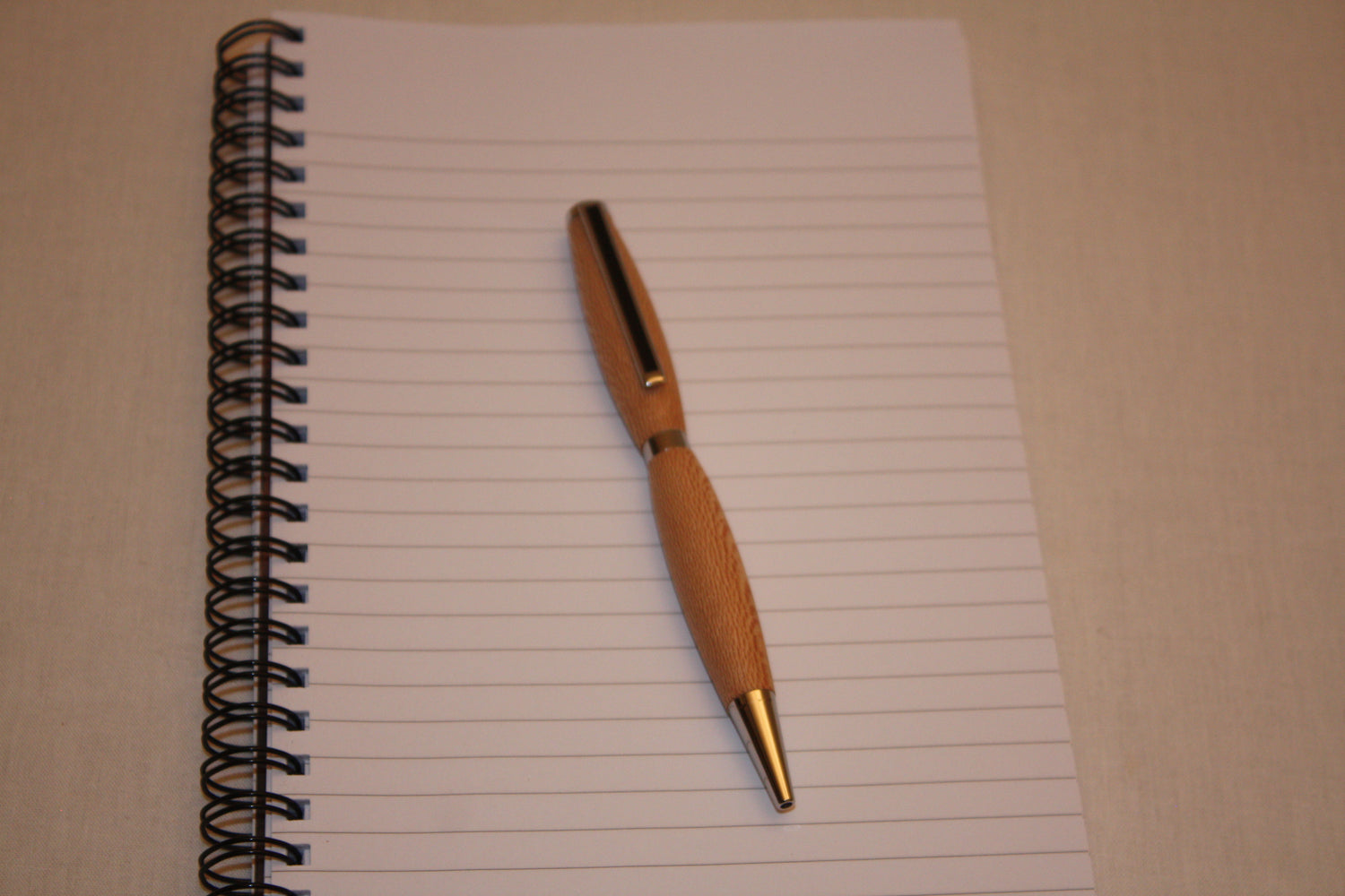Stylo bille en platane fabriqué de façon artisanale. La couleur d'écriture de ce stylo est noire.  