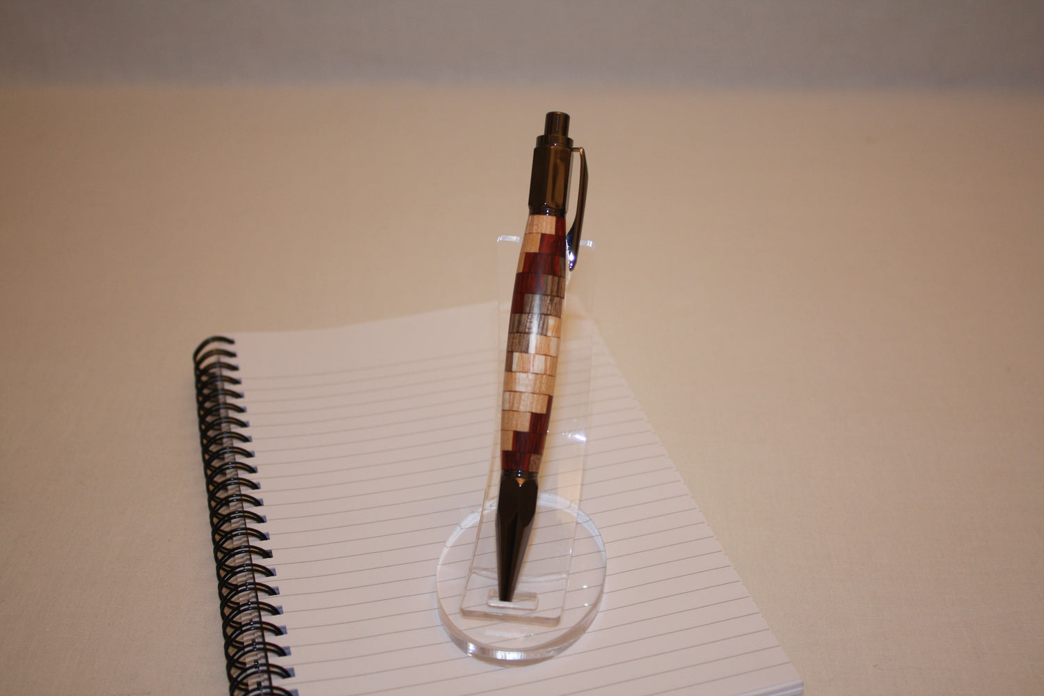 Stylo poussoir "spirale" en noyer, frêne, cerisier et padouk. Ses extrémités ciselées offrent un grand confort d'écriture. Ce stylo a une écriture fine et utilise des recharges type Parker.