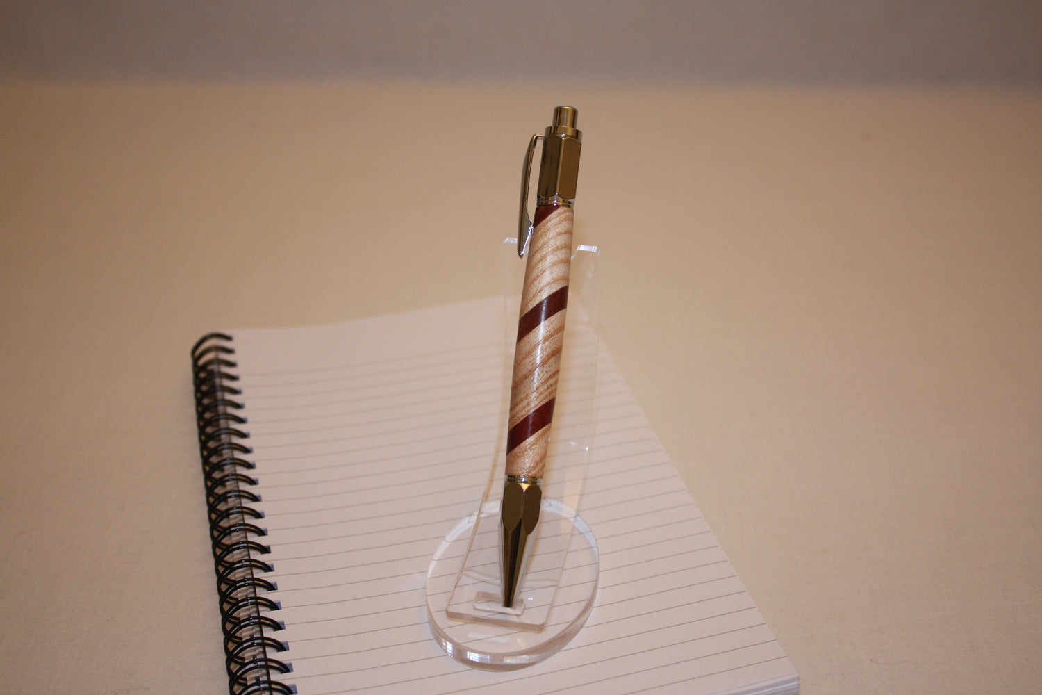 Stylo poussoir en frêne et padouk. Ses extrémités ciselées offrent un grand confort d'écriture. Ce stylo a une écriture fine et utilise des recharges type Parker.