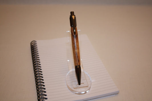 Stylo poussoir en bois de serpent. Ses extrémités ciselées offrent un grand confort d'écriture. Ce stylo a une écriture fine et utilise des recharges type Parker.