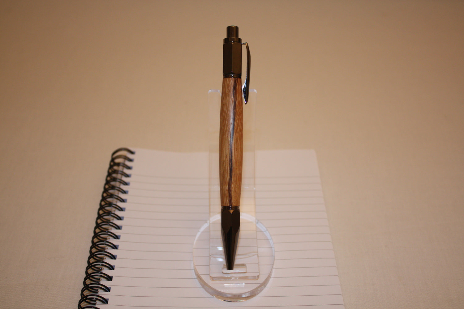 Stylo poussoir en bois de serpent. Ses extrémités ciselées offrent un grand confort d'écriture. Ce stylo a une écriture fine et utilise des recharges type Parker.