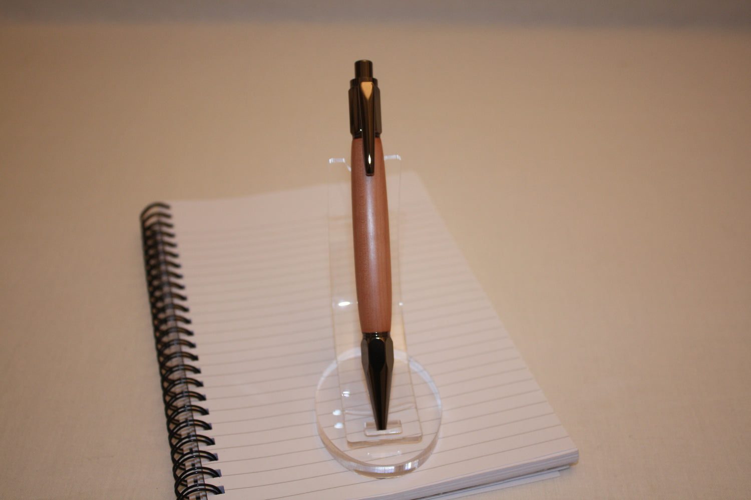 Stylo poussoir en alisier. Ses extrémités ciselées offrent un grand confort d'écriture. Ce stylo a une écriture fine et utilise des recharges type Parker.