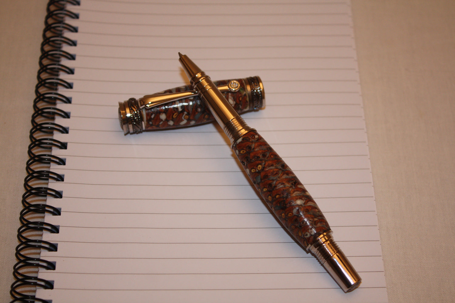 Stylo très haut de gamme en résine et pomme de pin. le mécanisme de ce stylo d'exeption est en rhodium et titane noir. Un cristal Swarovski orne l'extrémité de la barette du stylo.