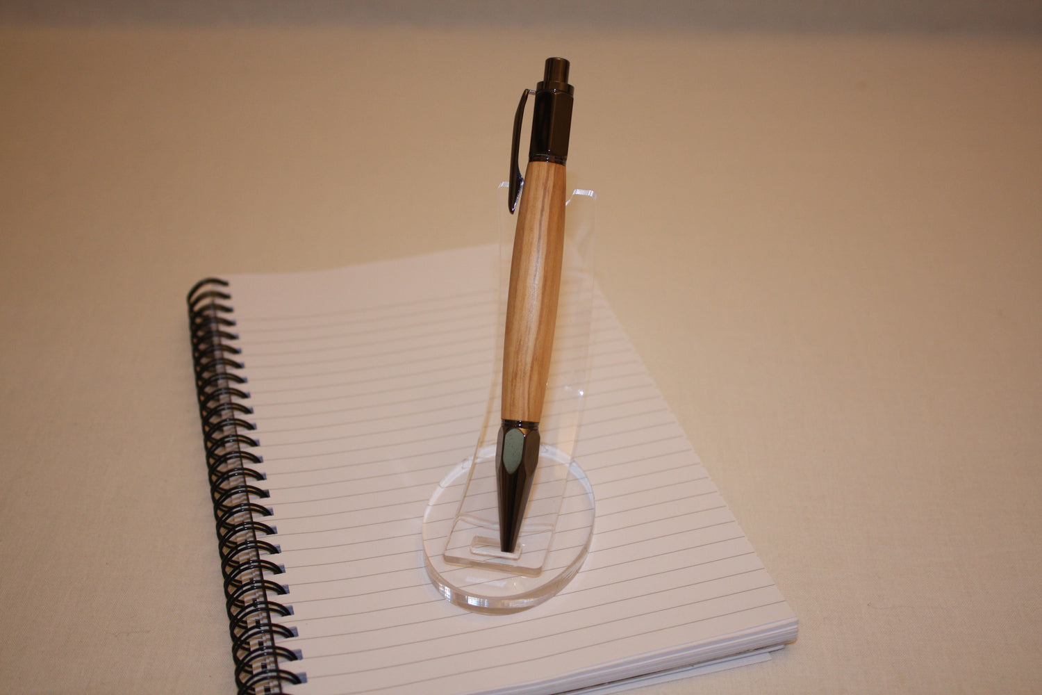 Stylo poussoir en olivier. Ses extrémités ciselées offrent un grand confort d'écriture. Ce stylo a une écriture fine et utilise des recharges type Parker.