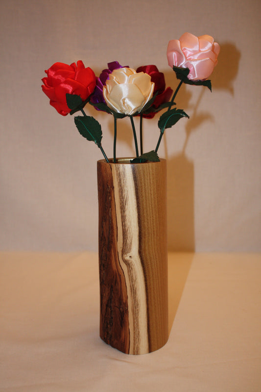 Vase en bois d'acacia avec écorce. A l'intérieur du vase se trouve un verre ce qui permet d'y ajouter de l'eau. C vase fait 22 cm de haut.